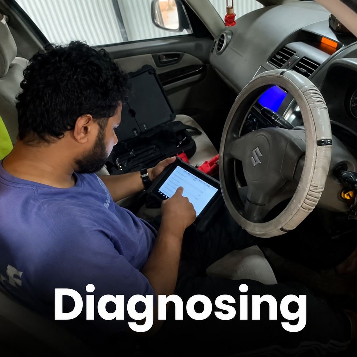 Technician running a computerised diagnostic scan on a car at Thenath Motors